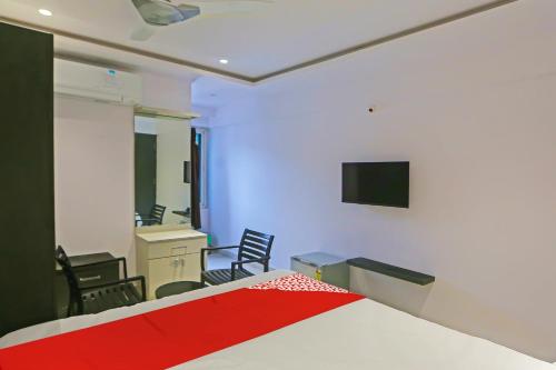 a bedroom with a bed and a tv on the wall at Super Hotel O Botcha Convection in Visakhapatnam