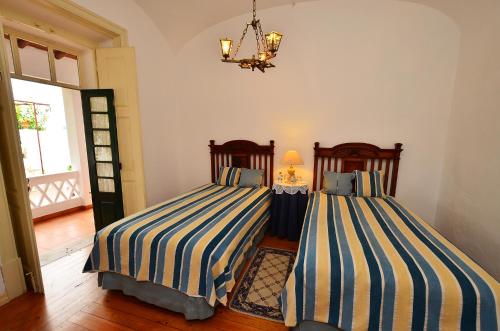 two beds in a room with a blue wall at Casa de Serpa - Turismo Rural in Serpa