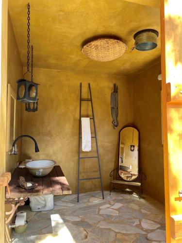 a room with a sink and a ladder and a mirror at Nest 1 in Delfinópolis