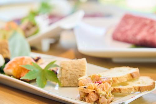 a plate with a sandwich and bread on a table at ICHIFUJI Ryokan in Hitoyoshi