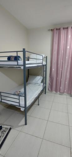 two bunk beds in a room with a window at Muscat Galaxy Hostel in Muscat