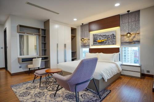 a bedroom with a bed and a table and a chair at URBAN PALACE in Phnom Penh