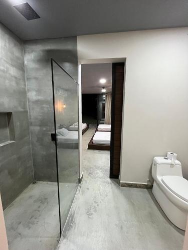 a bathroom with a shower and a toilet and a mirror at Finca Luxury en Doradal Antioquia in Puerto Triunfo