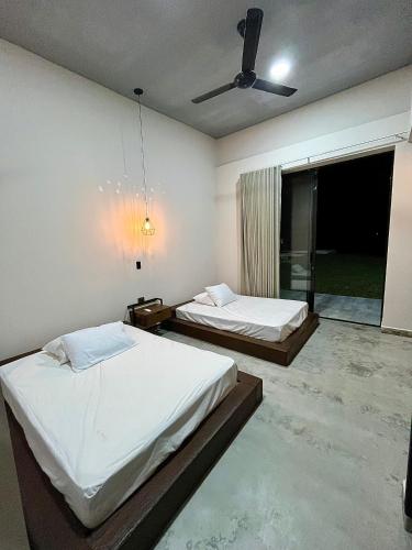 a bedroom with two beds and a ceiling fan at Finca Luxury en Doradal Antioquia in Puerto Triunfo