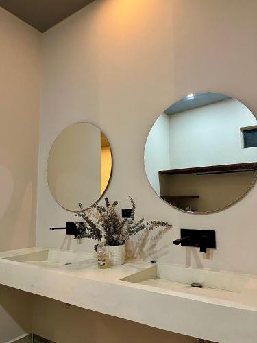 a bathroom with two sinks and two mirrors at Finca Luxury en Doradal Antioquia in Puerto Triunfo