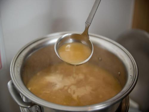 a spoon is in a pot with a soup at Sun Palace Kyuyokan in Naha