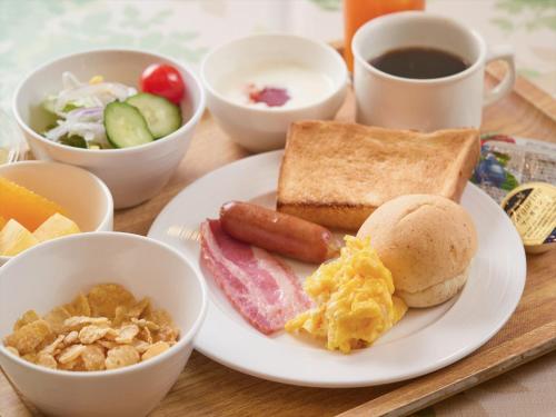 a plate of breakfast food with eggs sausage and toast at Sun Palace Kyuyokan in Naha