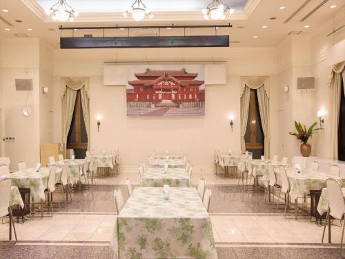 a banquet hall with white tables and chairs at Sun Palace Kyuyokan in Naha
