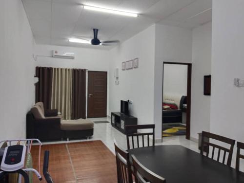 a dining room and living room with a table and chairs at Nufa homestay-seri iskandar in Seri Iskandar
