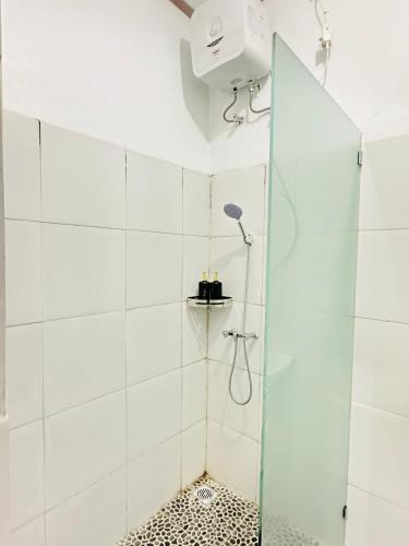een douche met een glazen deur in een badkamer bij Gatep Tree in Uluwatu