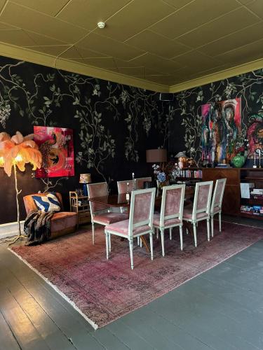 a dining room with chairs and a table and a couch at Grå Gåsen in Burgsvik