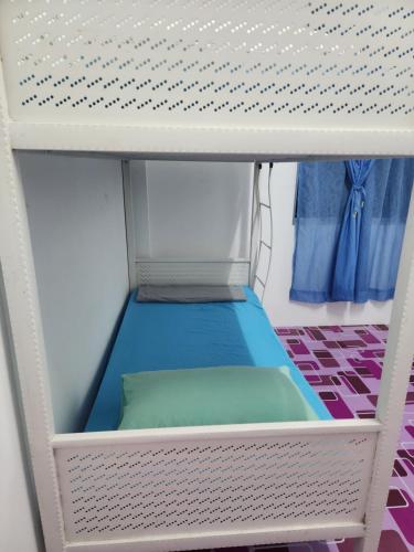 a bunk bed with a blue mattress on a shelf at Homestay Zaishazali in Gelugor