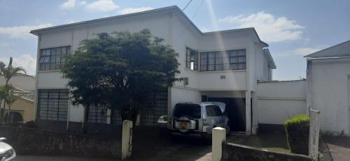 a white house with a truck parked in front of it at Casa para ferias manizales in Manizales