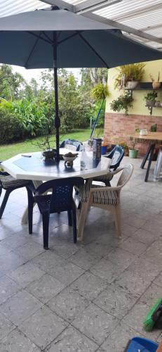 a table and a bench under an umbrella at Casa para ferias manizales in Manizales