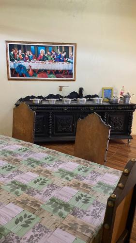 a dining room with a table and a counter with pots and pans at Chalé Dona Jandira in Sao Paulo