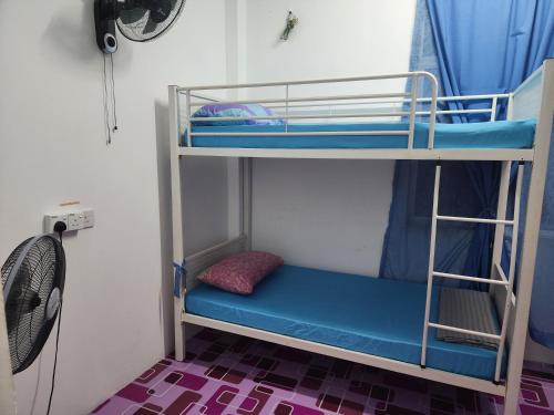 two bunk beds in a room with a fan at Homestay Zaishazali in Gelugor