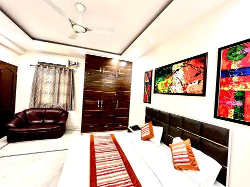 a living room with a couch and a chair at South Inn - Green Park South Delhi in New Delhi