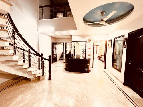 a living room with a staircase and a ceiling fan at South Inn - Green Park South Delhi in New Delhi