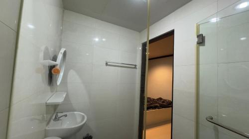Un baño blanco con lavabo y ducha. en The Haven Sabi, en Bangkok