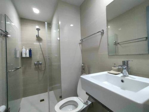 Un baño con inodoro, lavabo y ducha. en 101newport Condotel Near NAIA T3, en Manila