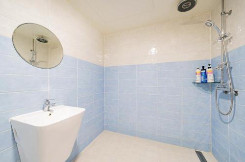 a blue tiled bathroom with a shower and a sink at Shampoo Hotel Incheon in Incheon