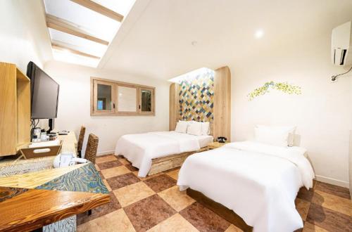 a hotel room with two beds and a tv at Shampoo Hotel Incheon in Incheon