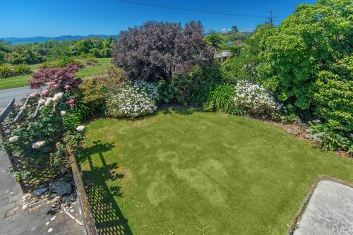 an aerial view of a yard with flowers and plants at Kina Beach House in Tasman