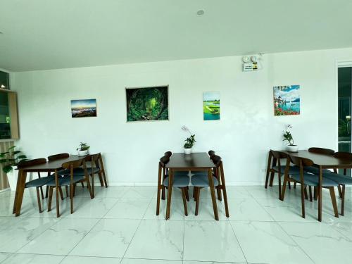 a room with tables and chairs and paintings on the wall at GRAND PA Hotel&Resort Lamphun Chiang Mai in Lamphun