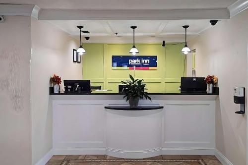 a lobby with a waiting area with a potted plant at Park Inn by Radisson in Grove City