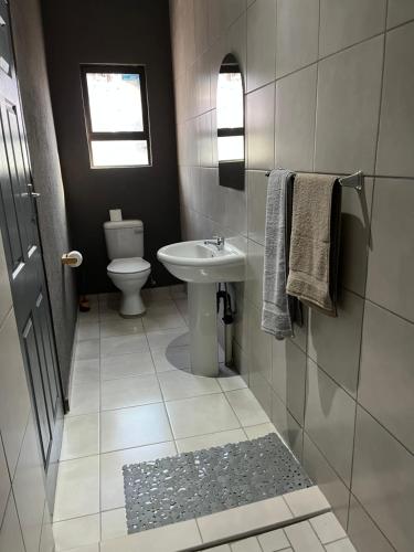 a bathroom with a toilet and a sink at Família BnB in Tekwane
