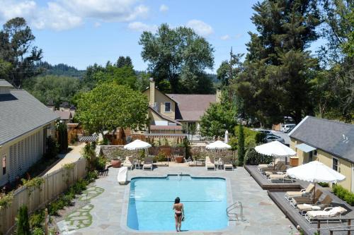 a woman is standing in front of a swimming pool at Farmhouse Inn in Forestville
