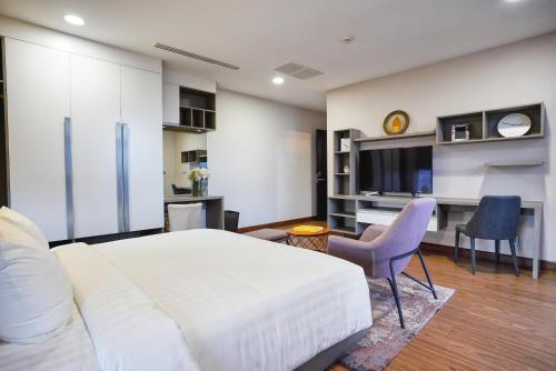 a bedroom with a large white bed and a tv at URBAN PALACE in Phnom Penh
