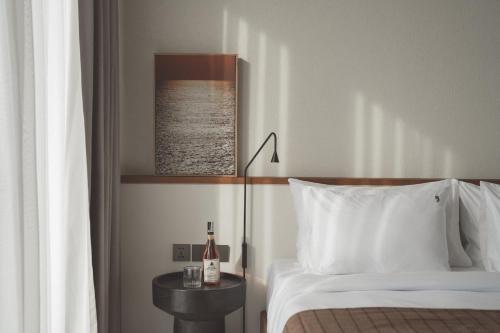 a bedroom with a bed and a table with a bottle of wine at SOKO' Stay at Kedungu in Tanah Lot