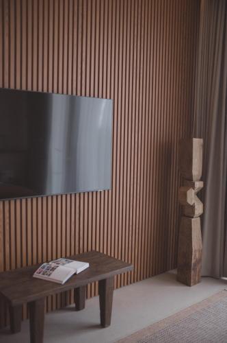 a living room with a tv and a coffee table at SOKO' Stay at Kedungu in Tanah Lot