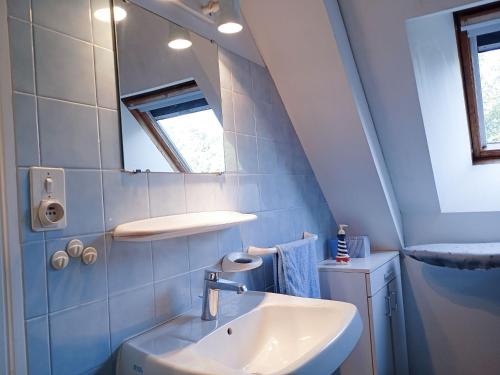 une salle de bain avec un lavabo et un miroir dans l'établissement Maison charmante près du château de Suscinio avec jardin et parking - FR-1-639-128, à Sarzeau