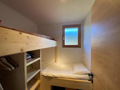 Cette petite chambre comprend des lits superposés et une fenêtre. dans l'établissement Studio 3 pers, Cernix : proche pistes, terrasse, parking - FR-1-733-160, à Crest-Voland