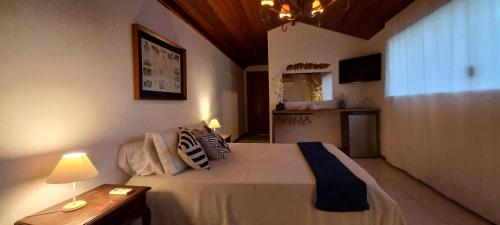 a bedroom with a bed and a table with a lamp at Casa Valldemossa in Búzios