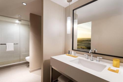 a bathroom with a sink and a mirror and a toilet at JW Marriott Los Angeles L.A. LIVE in Los Angeles