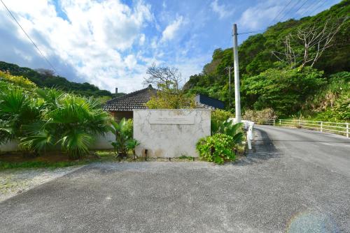 a house on the side of a road at ヴィラコガチアラマンダ in Nago