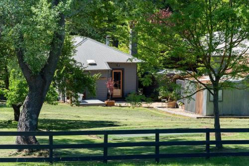 a house with a fence in a yard at WAIRERE REST - High Country Couples Retreat - Outdoor Bath with Rural View in Piries