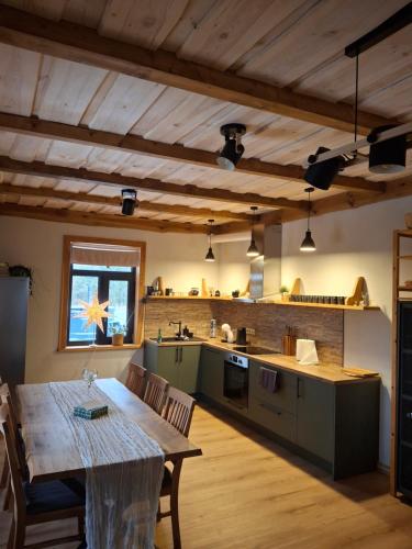 a kitchen with a table and a dining room at Guest house Kalnieši in Madona