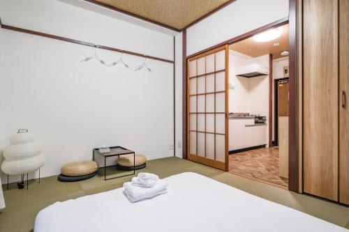 a bedroom with a white bed and a bathroom at Fuukanto Kinshicho BNB in Tokyo