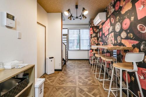 a room with a bar with stools in it at Fuukanto Kinshicho BNB in Tokyo