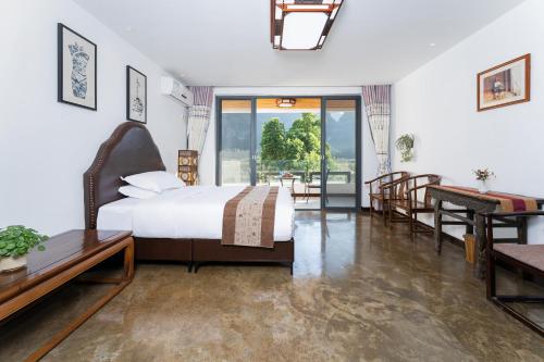 a bedroom with a bed and a table and a desk at Leisure Courtyard Hotel Yangshuo in Yangshuo