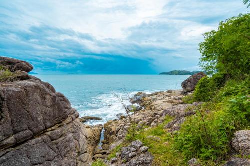 a view of the ocean from a rocky shoreline at Ocean Pearl Seaview Residence in Rawai Beach
