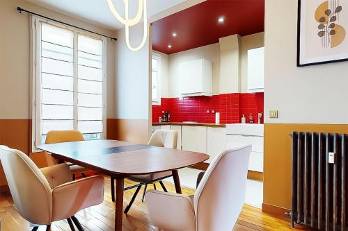 - une cuisine avec une table à manger et des chaises dans l'établissement L'écrin Havana , magnifique appartement hypercentre, à Clichy