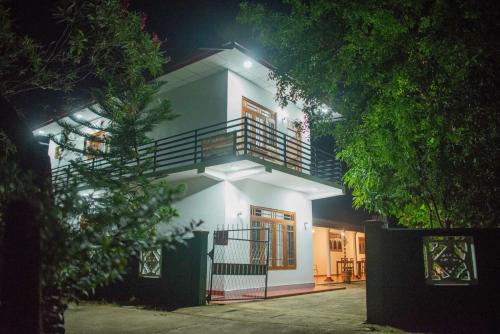 a white house with a staircase in front of it at AMA HomeStay in Udawalawe