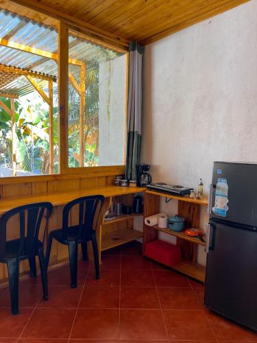 a kitchen with a table and chairs and a refrigerator at Cabañas del Lago in San Pedro La Laguna