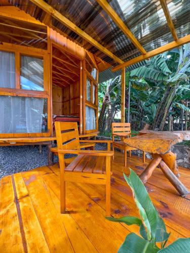 a wooden porch with two chairs and a table at Cabañas del Lago in San Pedro La Laguna