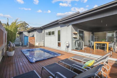 a deck with chairs and a swimming pool on a house at Mingalar in Cowes